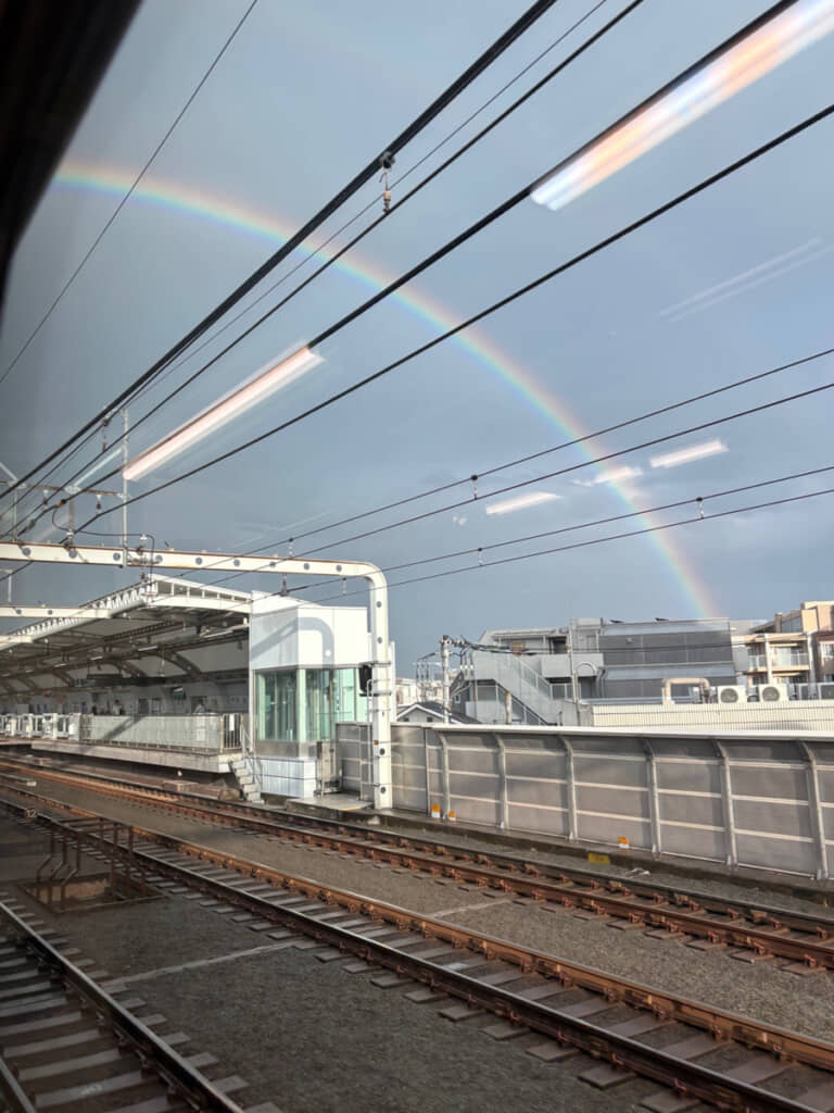 車掌が「独り言」として教えてくれたきれいな虹(写真は電車の向きが変わり、右手に見えるようになったあとのもの)