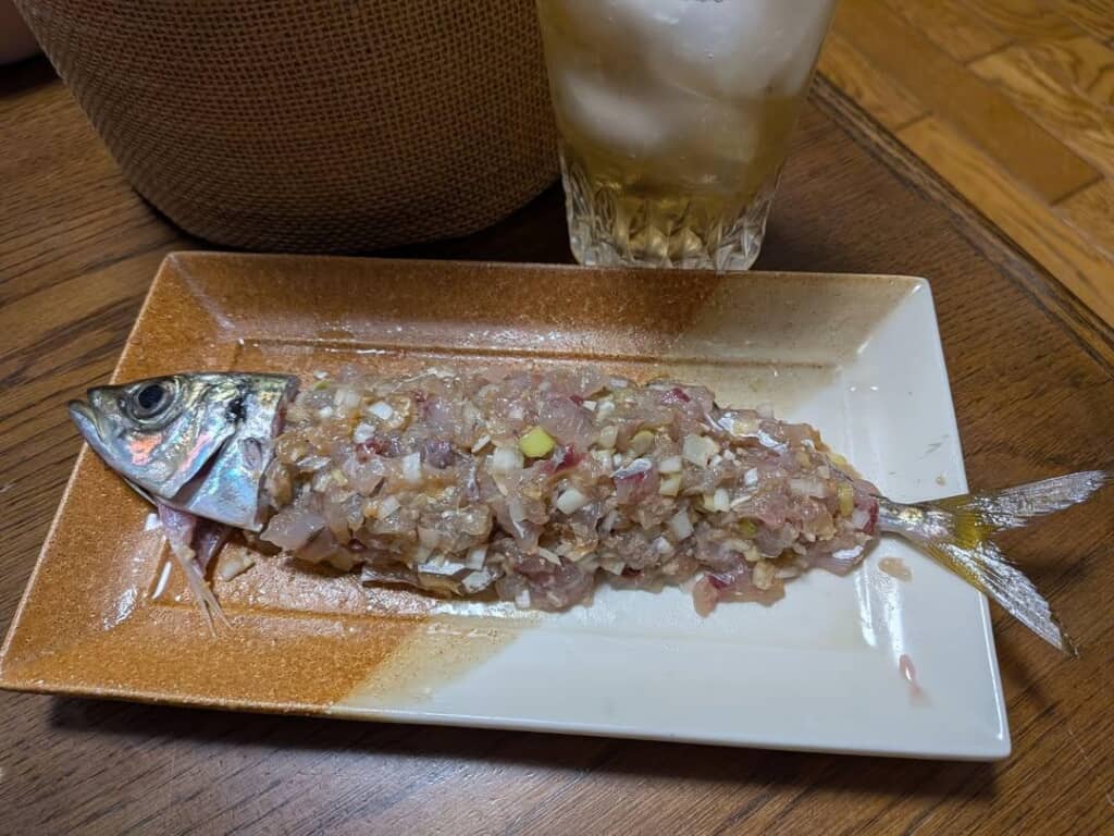 頭と尾ビレの間を埋めるように皿へ盛り付けたアジのなめろう