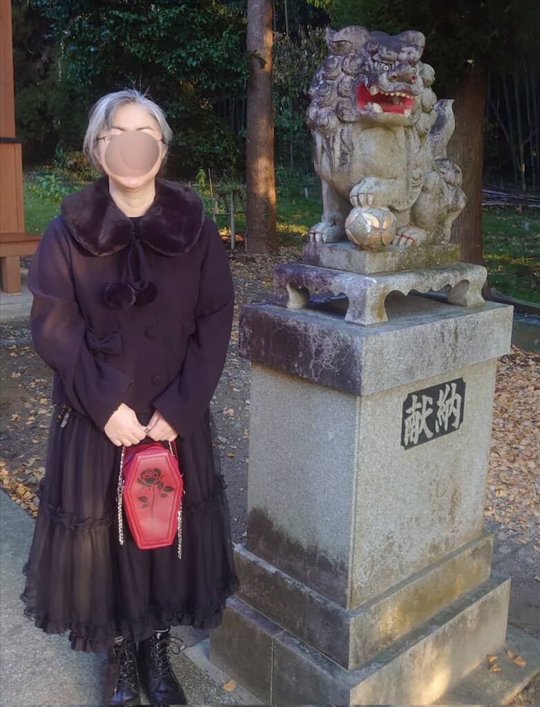 黒コーデに赤のバッグが差し色として映えています